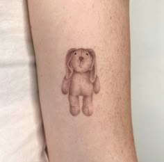 a small tattoo of a dog on the arm