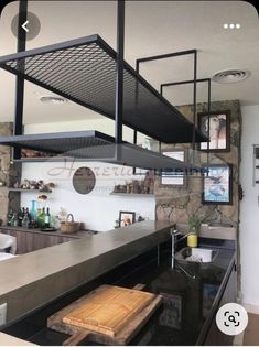 an industrial style kitchen with black counter tops and stainless steel shelving above the stove