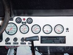 there are many gauges on the dashboard of this vehicle that is white and black