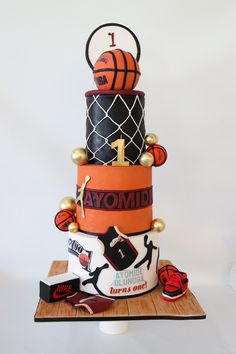 a three tiered cake decorated with basketballs and other sports related items