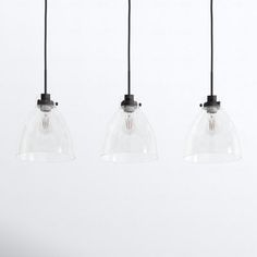 three clear glass pendant lights hanging from black cords