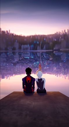 two people sitting on the edge of a body of water looking at cityscape