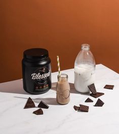 some chocolate pieces and a bottle of milk on a table