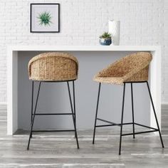 two wicker bar stools in front of a white table