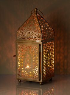 an intricately designed lantern is lit on a shiny surface