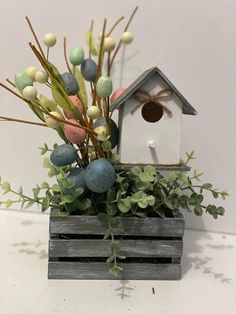 a birdhouse filled with eggs and greenery