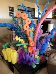 an arrangement of balloons and streamers on a table in a living room with a fireplace