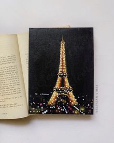 an open book with the eiffel tower painted on it