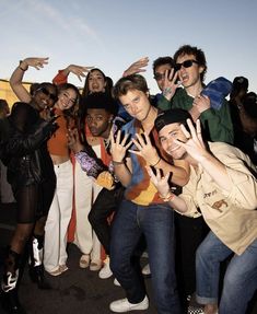 a group of young people standing next to each other with their hands in the air