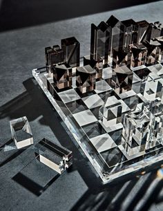 a glass chess board with several pieces on the table next to it and one piece missing