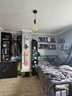 a bed room with a neatly made bed and a skateboard hanging on the wall