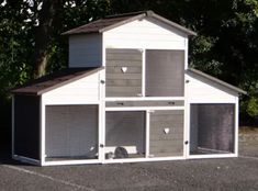 a white and gray dog house sitting in the middle of a parking lot