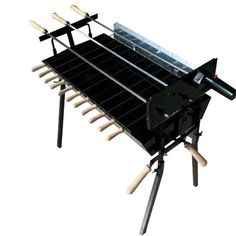 a black grill with wooden utensils attached to it