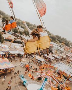 two people ride on swings at an amusement park