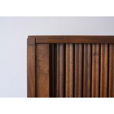 a wooden headboard with vertical slats on the top and bottom part of it