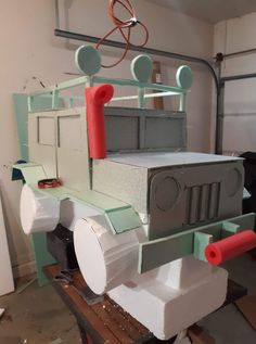 a vehicle made out of toilet paper on a workbench with tools and other items