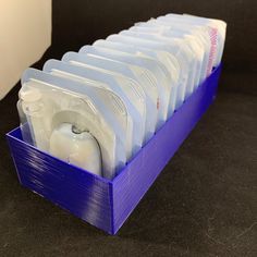 a blue plastic container filled with lots of white items on top of a black counter