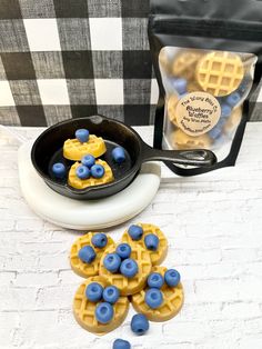 blueberries and waffles in a cast iron skillet next to a bag of powdered sugar