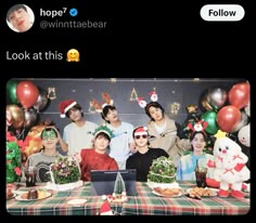 a group of people standing in front of a table with food and decorations on it