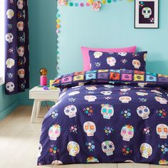 a bed room with a neatly made bed and colorful decorations on the wall above it