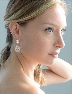 a woman with blue eyes wearing large earrings