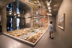 a man standing in front of a large model of a river