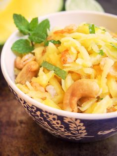 a blue and white bowl filled with food on top of a table