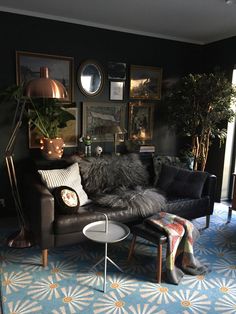 a living room filled with lots of furniture and pictures on the wall next to a window