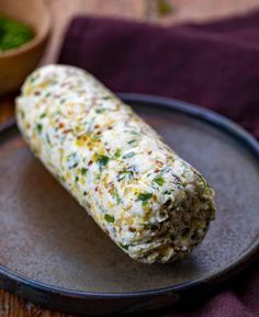 a close up of a food item on a plate with a bowl in the background