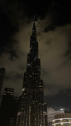 a very tall building lit up in the night sky with lights on it's sides