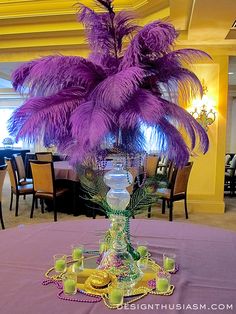 a vase with purple feathers on top of a table in a room filled with tables and chairs