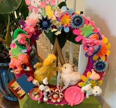 a wreath with flowers and stuffed animals on it