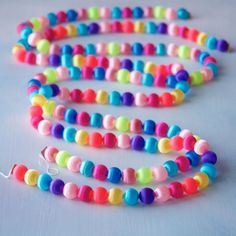 multicolored beads are arranged on a white surface with a string attached to it