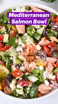 a salad with salmon, cucumber, tomatoes and feta cheese in it