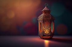 a lit lantern sitting on top of a table next to a light shining in the background