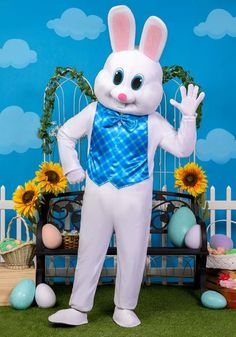 a man dressed in an easter bunny costume standing next to a bench with sunflowers