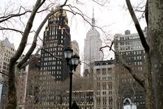 people are walking around in the park near tall buildings