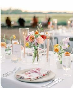 the table is set with flowers and candles