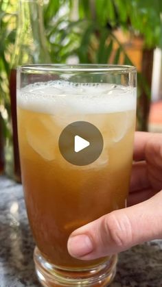 a person holding a glass with liquid in it