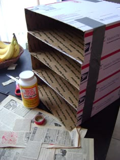 several boxes stacked on top of each other with bananas in the background and newspaper scattered around them