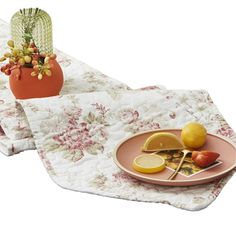 two placemats with fruit and flowers on them