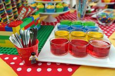 a table topped with lots of cups filled with liquid and candy bars on top of it