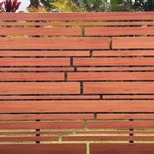 an empty wooden bench in front of some trees