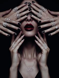 a woman with her hands on her face and many different rings around her eyes, all in various shapes and sizes