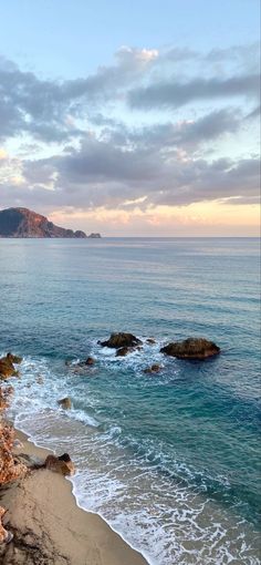 the beach is next to some rocks and water