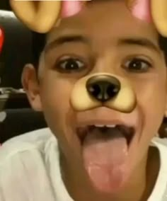 a young boy making a silly face with doughnuts on his ears and nose