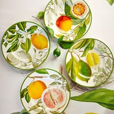 four plates with fruit painted on them