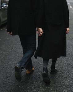 two people walking down the street holding hands