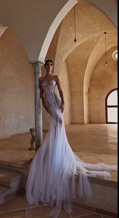 a woman in a white dress standing on some steps