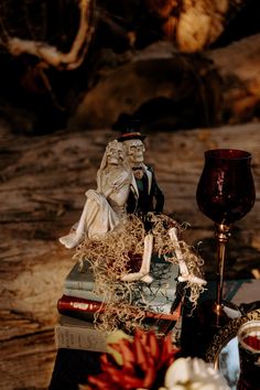 there is a figurine sitting on top of some books next to a candle